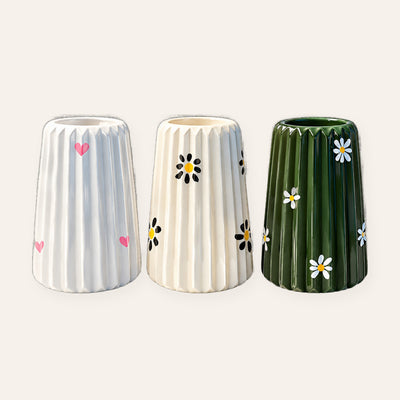 Painted fluted vases with pink hearts, black daisies and green daisies